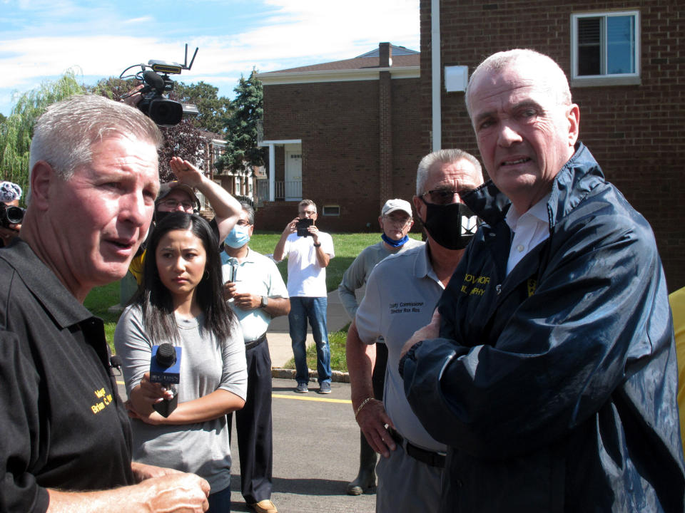 Piscataway Mayor Brian Wahler, left, briefs New Jersey Gov. Phil Murphy, right, on damage to an apartment complex located along the banks of the Raritan River on Saturday Sept. 4, 2021 after the remnants of Tropical Storm Ida caused major flooding. (AP Photo/Wayne Parry)