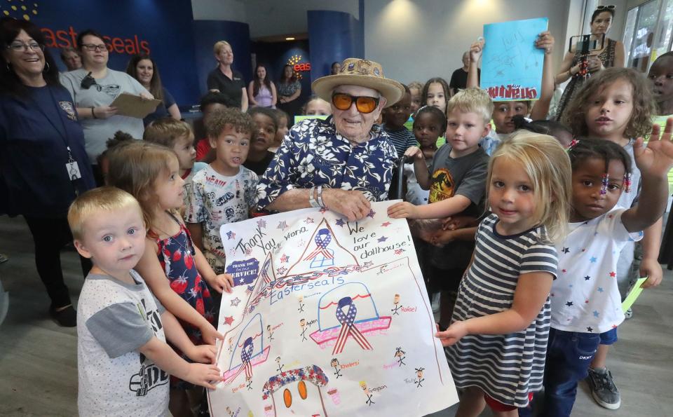 Youngsters give World War II veteran Ed Vrona a big thank you card for donating a dollhouse he built to the Easterseals Autism Center of Excellence in Daytona Beach. Vrona died on Friday, July 14, just 10 days after his 104th birthday.