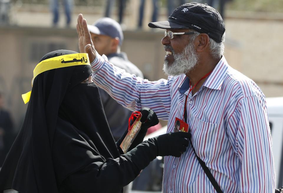 A couple, who are supporters of the Muslim Brotherhood and ousted Egyptian President Mohamed Mursi, take part in a protest outside the police academy, where Mursi's trial took place, on the outskirts of Cairo