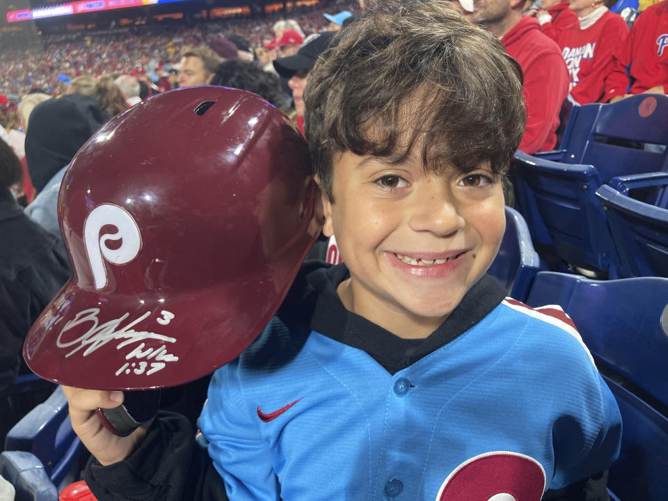 Hayden Dorfman, 10, of Voorhees, N.J., holds up Philadelphia Phillies slugger Bryce Harper’s autographed helmet during a baseball game against the Pittsburgh Pirates, Thursday, Sept. 28, 2023, in Philadelphia. Harper tossed his helmet into the stands after he was ejected and it was retrieved by Dorfman. (AP Photo/Daniel Gelston)