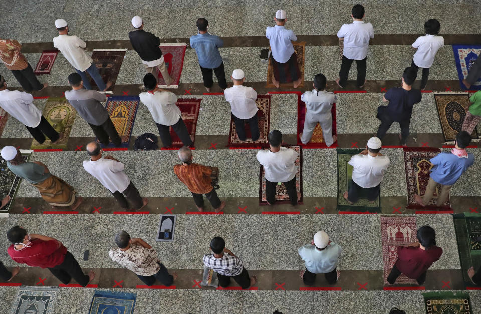 Muslim men pray on physical distancing markers as a precaution against the new coronavirus outbreak are seen on the floor during a Friday prayer at the At-Tin mosque in Jakarta, Indonesia, Friday, June 5, 2020. Muslims in Indonesia's capital held their first communal Friday prayers as mosques closed by the coronavirus outbreak for nine weeks reopened at half capacity. (AP Photo/Achmad Ibrahim)