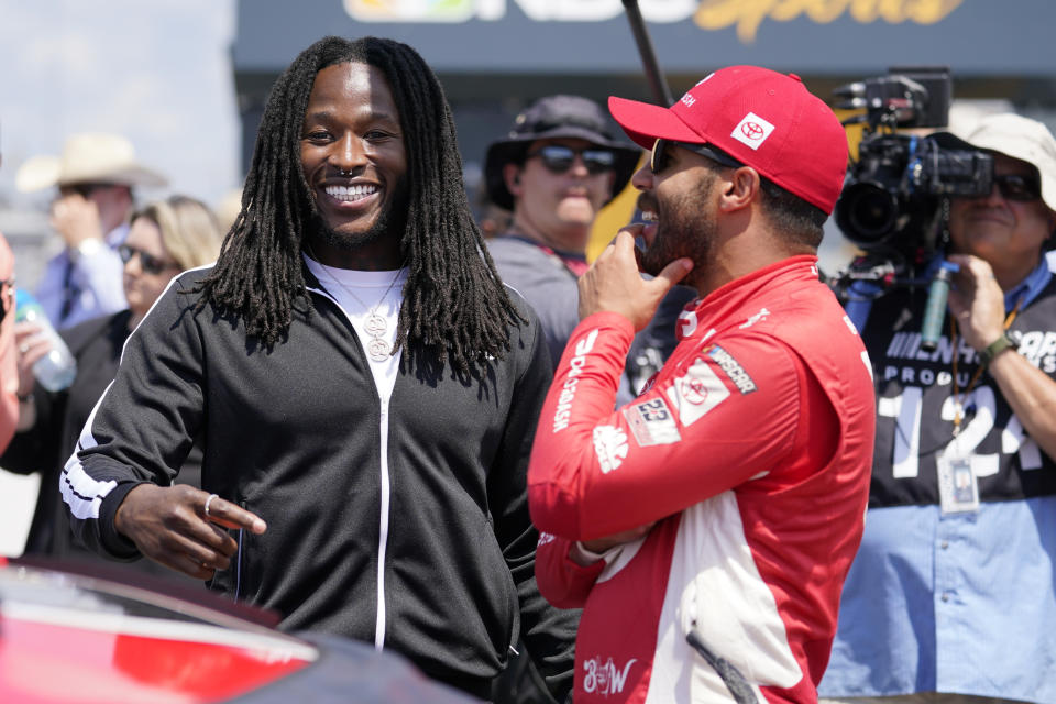 Alvin Kamara, left, running back with the NFL football New Orleans Saints, talks with driver Bubba Wallace before a NASCAR Cup Series auto race at Nashville Superspeedway Sunday, June 20, 2021, in Lebanon, Tenn. (AP Photo/Mark Humphrey)