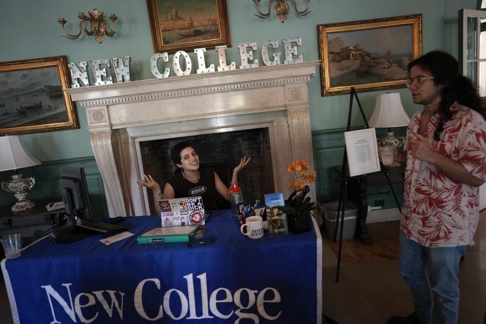 Anthropology major Gaby Batista, 19, talks with Cas Rizzo at New College of Florida's Admissions Welcome Center where they both work as student ambassadors, Wednesday, March 1, 2023, in Sarasota, Fla. Batista, who identifies as pansexual, non-binary, and uses they/them pronouns, says of high school, "I was bullied for being different." At New College, Batista says, "We have this culture of radical acceptance, I would say. That leads to a lot of living authentically." (AP Photo/Rebecca Blackwell)