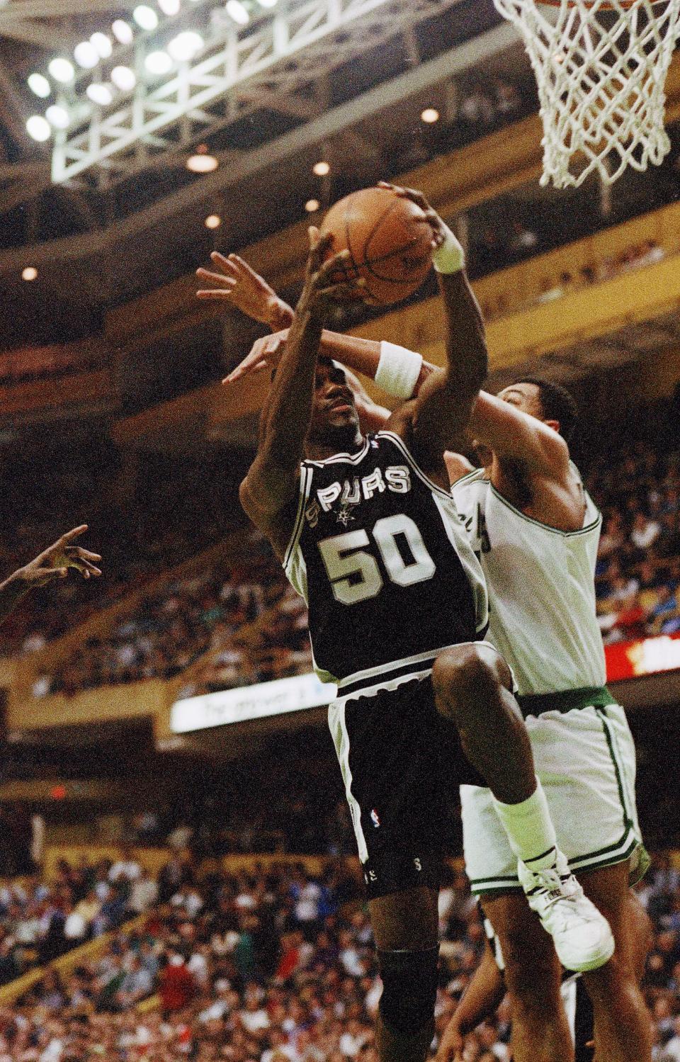 David Robinson (50) of the <a class="link " href="https://sports.yahoo.com/nba/teams/san-antonio/" data-i13n="sec:content-canvas;subsec:anchor_text;elm:context_link" data-ylk="slk:San Antonio Spurs;sec:content-canvas;subsec:anchor_text;elm:context_link;itc:0">San Antonio Spurs</a> gets hammered on his way to the basket by Alaa Abdelnaby of the Boston Celtics during first quarter action at Boston Garden, March 3, 1993. (AP Photo/Winslow Townson)