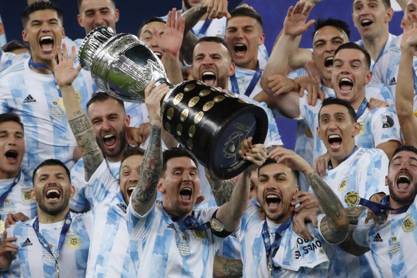FILE - Argentina's Lionel Messi celebrates with the trophy after beating Brazil 1-0 in the Copa America final soccer match at Maracana stadium in Rio de Janeiro, Brazil, Saturday, July 10, 2021. Messi and Argentina will try to win their third straight major title when they defend their Copa America championship while Brazil hopes 17-year-old Endrick will combine with Vinícius Júnior and Rodrygo for success. (AP Photo/Bruna Prado, File)