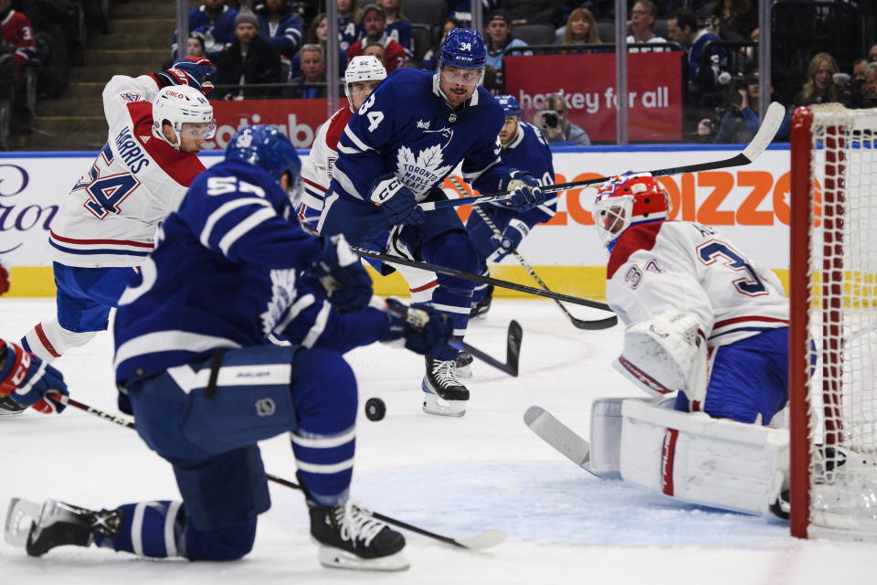 Toronto Maple Leafs forward Auston Matthews (34) passes to forward Michael Bunting (58) who scores against Montreal Canadiens goaltender Jake Allen (34) during second-period NHL hockey game action in Toronto, Saturday, Feb. 18, 2023. (Christopher Katsarov/The Canadian Press via AP)