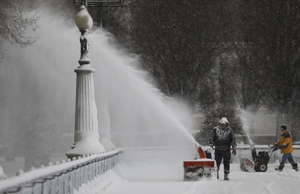 Men clears the snow inside the skating rink in Millennium Park, after a snow storm in Chicago Saturday Jan. 19, 2019. ( Abel Uribe/Chicago Tribune via AP)