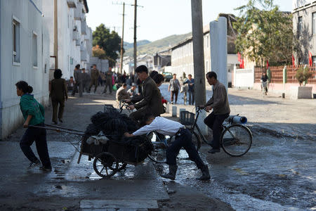 People pull and push a cart through the streets of central Wonsan, North Korea, October 2016. Christian Petersen-Clausen/Handout via REUTERS