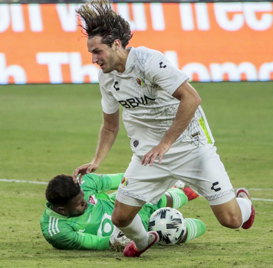 MLS goalie Andre Blake knocks the ball from Liga MX forward Santiago Giminez.