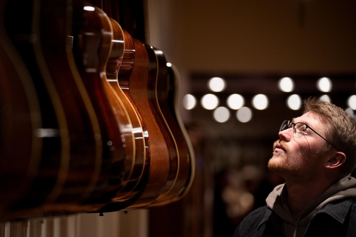 Elliott McGaha of Sevierville examines the acoustic guitars for sale at Carter Vintage Guitars in Nashville.