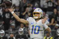 Los Angeles Chargers quarterback Justin Herbert (10) throws against the Las Vegas Raiders during the first half of an NFL football game, Sunday, Jan. 9, 2022, in Las Vegas. (AP Photo/David Becker)