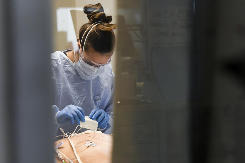 East Alabama Medical Center nurse Abby Smith works on a COVID-19 patient in the intensive care unit Thursday, Dec. 10, 2020, in Opelika, Ala. The medical center faces a new influx of COVID-19 patients as the pandemic intensifies. (AP Photo/Julie Bennett)