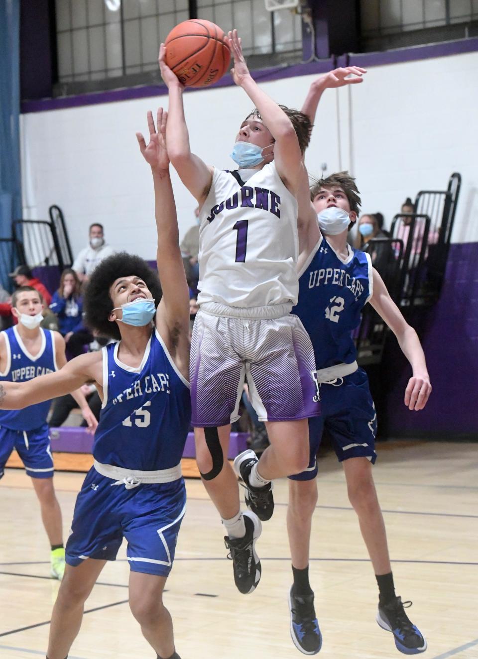 In this photo from January 2022, Shea Ullo of Bourne goes between Tajaan Souza (15) and Matt Newoichik of Upper Cape Tech
(Photo: Ron Schloerb/Cape Cod Times)