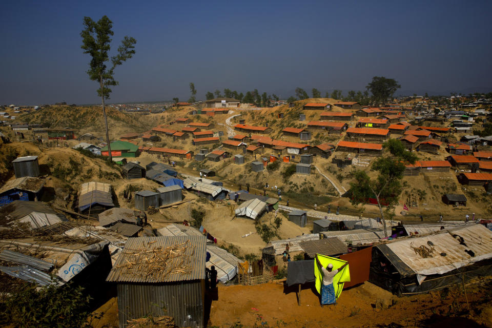 FILE - In this Jan. 23, 2018 file photo, a Rohingya refugee hangs a blanket out to dry at Balukhali refugee camp, about 50 kilometers (32 miles) from Cox's Bazar, Bangladesh. An island in Bangladesh that was submerged during the monsoon season is ready to house 100,000 Rohingya refugees, but no date has been announced to begin relocating people from crowded and squalid camps on the country's border with Myanmar, officials said Thursday. (AP Photo/Manish Swarup, File)