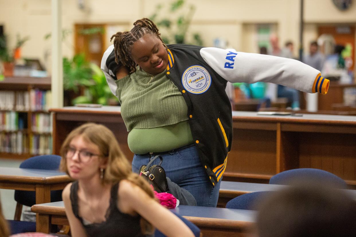 T’Ajahnae Ray puts on a College Prep Academy branded jacket she received for graduating from the program at a ceremony Thursday at Highland Park High School.