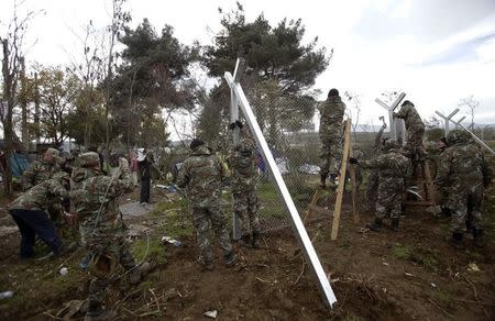 Macedonian soldiers erect a metal fence on the border with Greece, near Gevgelija, Macedonia, November 28, 2015. REUTERS/Stoyan Nenov