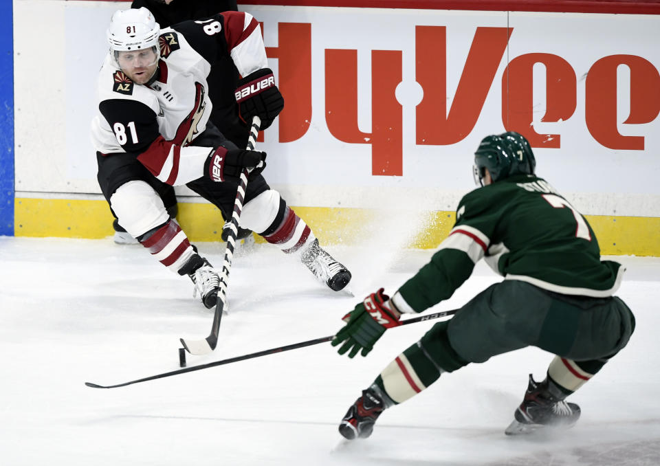 Arizona Coyotes' Phil Kessel (81) has the puck against Minnesota Wild's Nico Sturm (7), of Germany, during the first period of an NHL hockey game Sunday, March 14, 2021, in St. Paul, Minn. (AP Photo/Hannah Foslien)