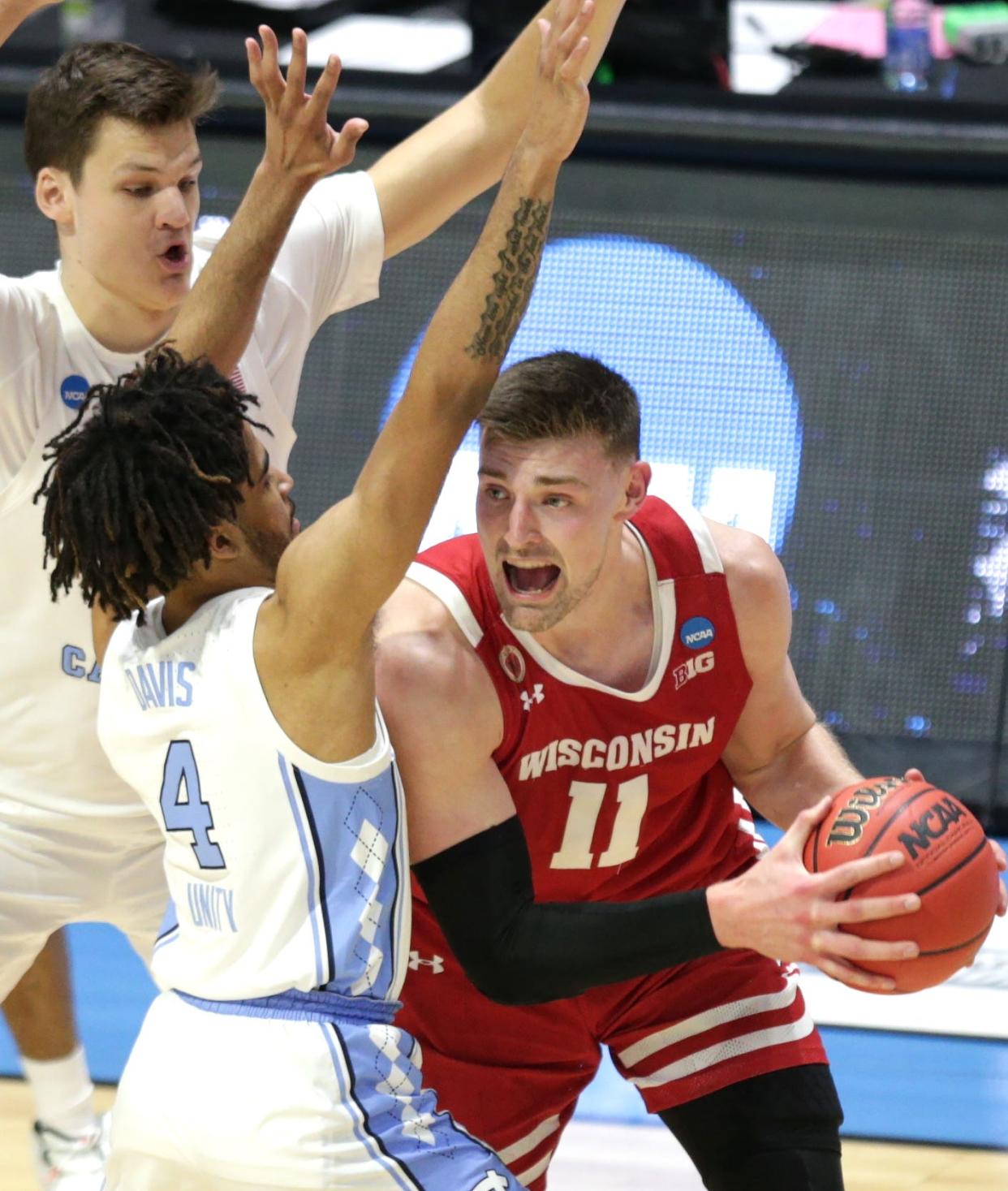 Badgers forward Micah Potter looks for a teammate to pass to while being double teamed by North Carolina's R.J. Davis (4) and Walker Kessler.