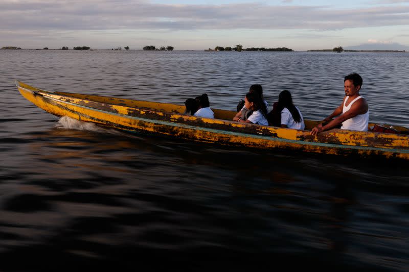 The Wider Image: Rising seas threaten early end for sinking village in Philippines