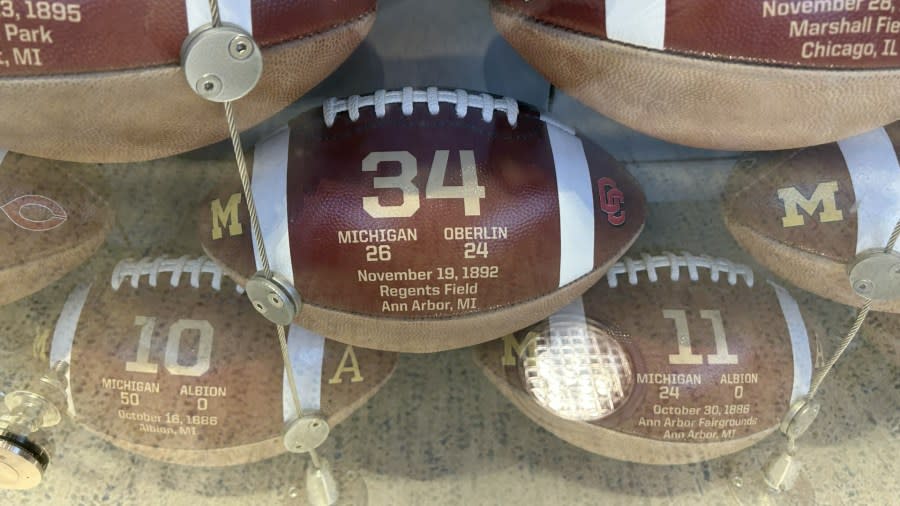 A football is commemorated with gold-plated writing, signifying the Michigan football program's 34th win -- a 26-24 win over Oberlin College.