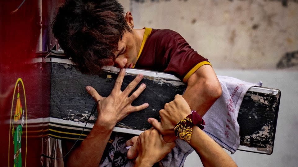 A young devotee hugs the statue of the Black Nazarene. The faithful believe the dark wood sculpture of Jesus has healing powers. - Ezra Acayan/Getty Images
