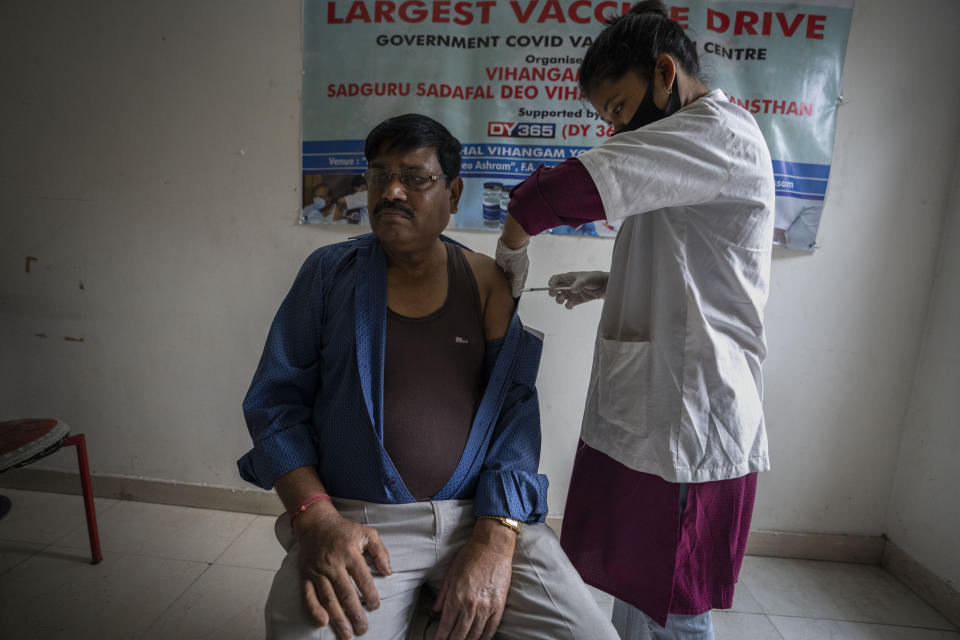 A man receives his third dose of vaccine for COVID-19 at a private vaccination center in Gauhati, India, Sunday, April 10, 2022. India began offering booster doses of COVID-19 vaccine to all adults on Sunday but limited free shots at government centers to front-line workers and people over age 60. (AP Photo/Anupam Nath)