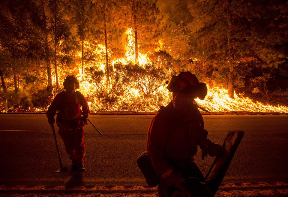 Firefighters battling the King Fire watch as a backfire burns along Highway 50 in Fresh Pond, California September 16, 2014. The fire led officials to call on about 400 people to evacuate from areas threatened by the blaze, Cal Fire spokeswoman Alyssa Smith said. It has charred more than 11,500 acres (4,654 hectares) and was 5 percent contained on Tuesday.  REUTERS/Noah Berger  (UNITED STATES - Tags: DISASTER ENVIRONMENT TPX IMAGES OF THE DAY)