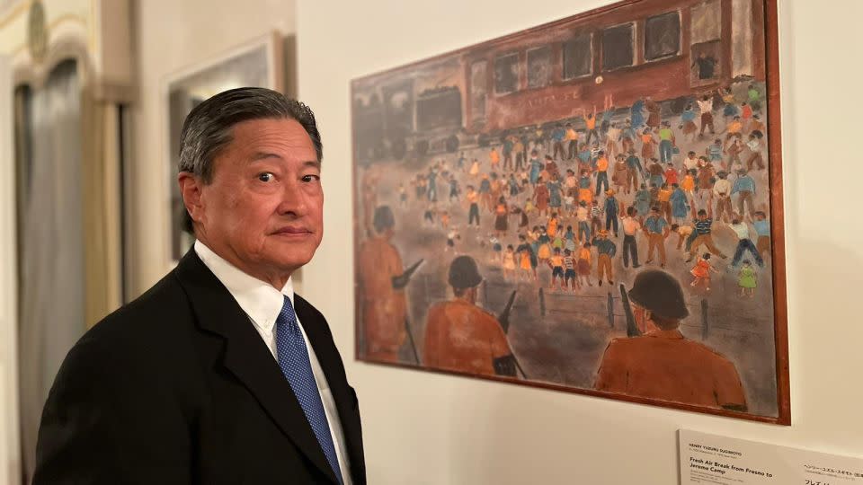 Vice chair of the Japanese American National Museum, Robert T. Fujioka, stood beside Henry Sugimoto's "Fresh Air Break from Fresno to Jerome Camp," a painting depicting the camp where Fujioka's own mother and grandfather were incarcerated. - Emiko Jozuka/CNN