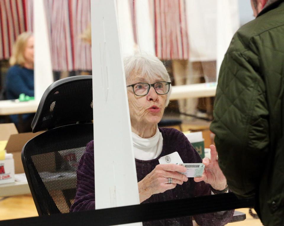 Exeter election official Kendra Gemmett checks identifications of voters as they check in at the polls March 12, 2024.