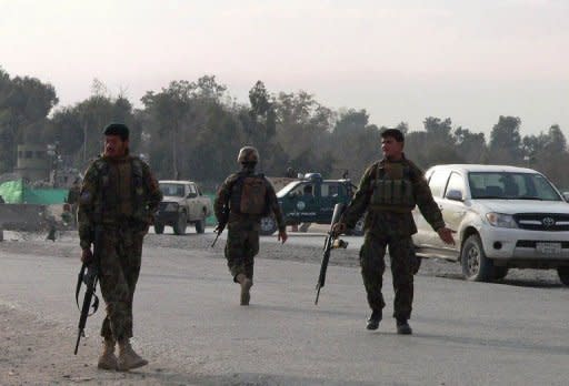 Afghan National Army (ANA) soldiers block a road at the site of a suicide attack in the city of Jalalabad in Nangarhar province. A Taliban suicide car bomber targeting NATO troops at an airport in eastern Afghanistan killed nine people Monday, the seventh day of violence over the burning of the Koran at a US airbase