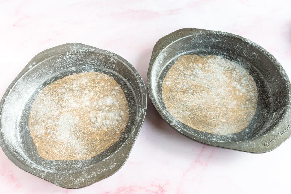 two cake tins, round, dusted with flour