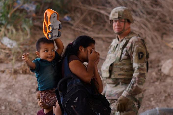 Migrants stand near the Rio Bravo river after crossing the border, to request asylum in the United States, as seen from Ciudad Juarez