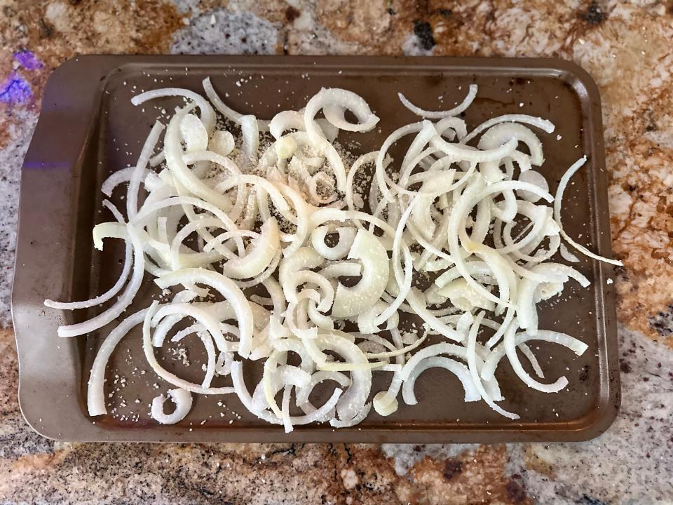 sliced yellow onion on a baking sheet