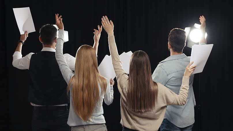 Actors holding up scripts