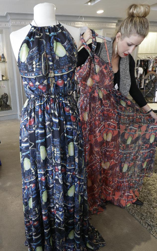 This March 6, 2014 photo shows senior stylist Tiffany Kimbrough adjusting a spring print dress on display at an Elements boutique in Dallas. (AP Photo/LM Otero)