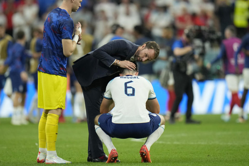 England's head coach Gareth Southgate comforts England's Harry Maguire at the end of the World Cup quarterfinal soccer match between England and France, at the Al Bayt Stadium in Al Khor, Qatar, Sunday, Dec. 11, 2022. France won 2-1. (AP Photo/Francisco Seco)