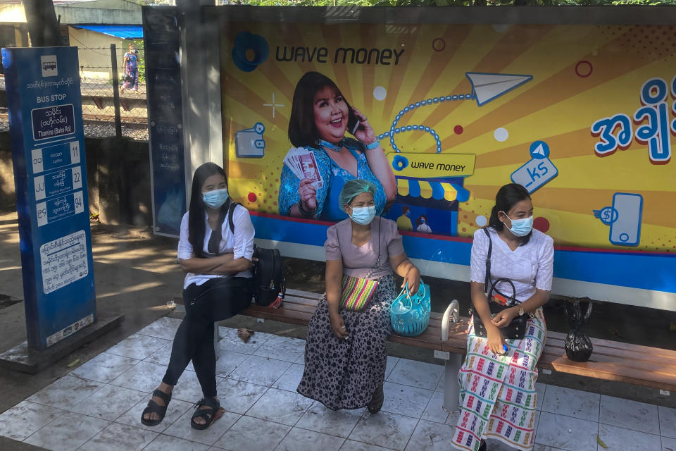 People wait for public transport at a bus station in Yangon, Myanmar on Nov. 12, 2021. The military takeover in Myanmar has set its economy back years, if not decades, as political unrest and violence disrupt banking, trade and livelihoods and millions slide deeper into poverty. (AP Photo)