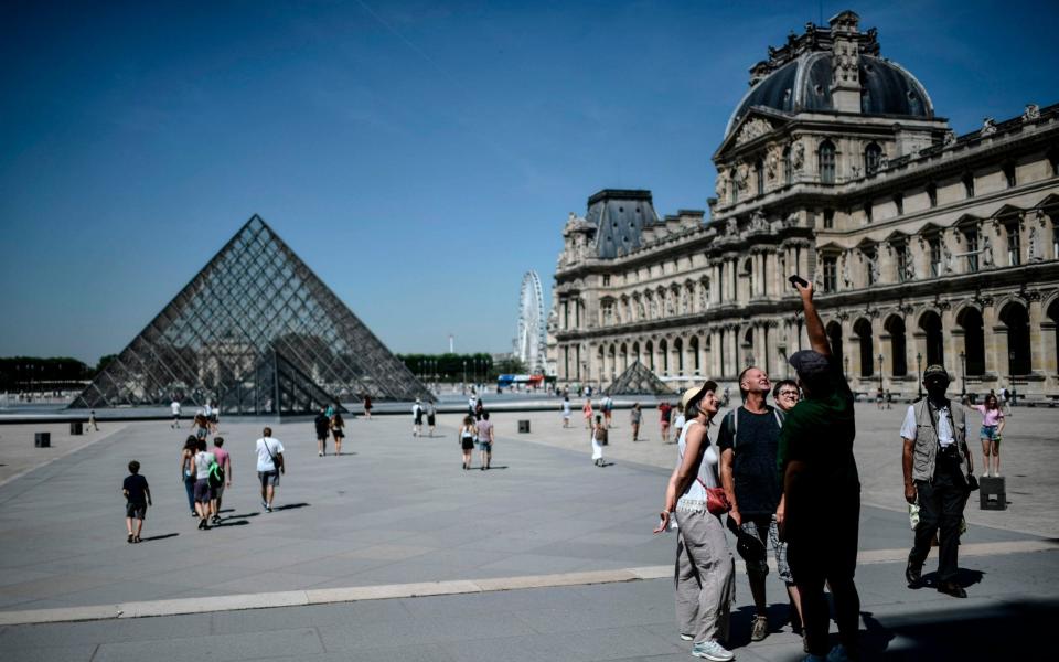 Tourists at the Louvre in Paris - STEPHANE DE SAKUTIN/AFP via Getty Images