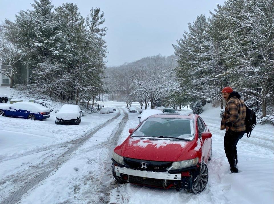 Elijah Clark, of Bellevue, starts his trek up the hillside of his apartment complex after heavy snows Sunday night and Monday morning made the driveway impassable for over 20 vehicles.