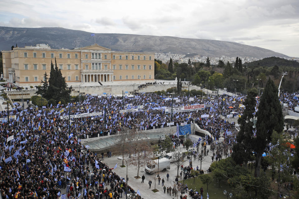 Protestors wave Greek flags outside parliament in Athens, Sunday, Jan. 20, 2019. Greece's Parliament is to vote this coming week on whether to ratify the agreement that will rename its northern neighbor North Macedonia. Macedonia has already ratified the deal, which, polls show, is opposed by a majority of Greeks. (AP Photo/Thanassis Stavrakis)