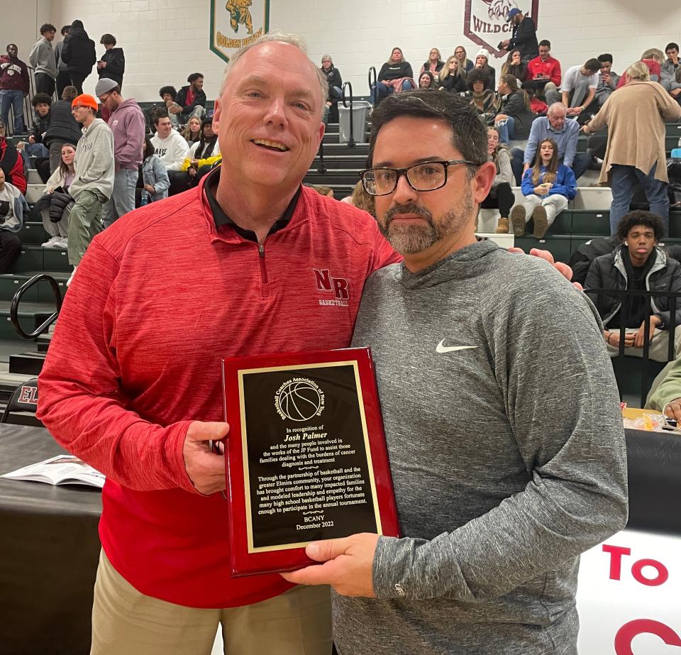 North Rockland girls coach Kevin Metcalf presents Josh Palmer a plaque recognizing the work of Palmer and others in helping the community through the Josh Palmer Fund and the Palmer tournament at halftime of the boys game between Elmira and Mount St. Michael on Dec. 28, 2022 at Elmira High School.