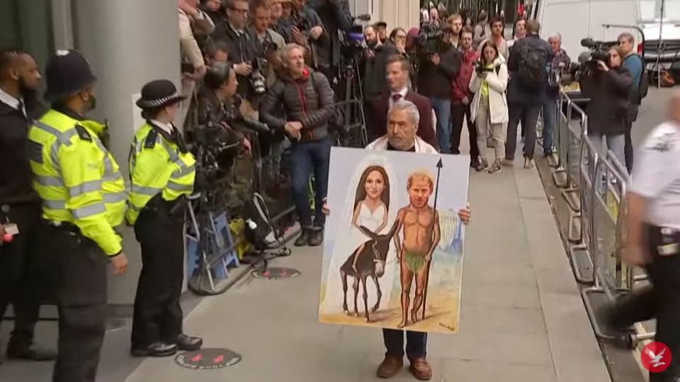 A man has appeared outside the High Court with a placard of Harry and Meghan dressed up as Mary and Joseph (The Independent)