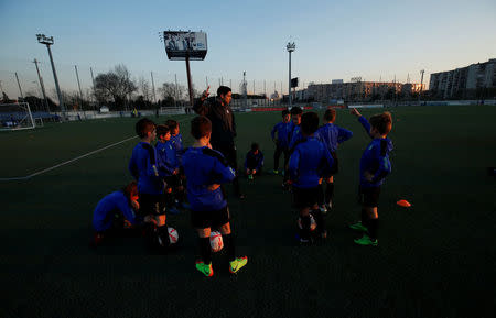 Boys from the RCD Espanyol soccer academy listen to their coach during a training session at Dani Jarque training camp in Sant Adria de Besos, near Barcelona, Spain February 20, 2017. REUTERS/ Albert Gea