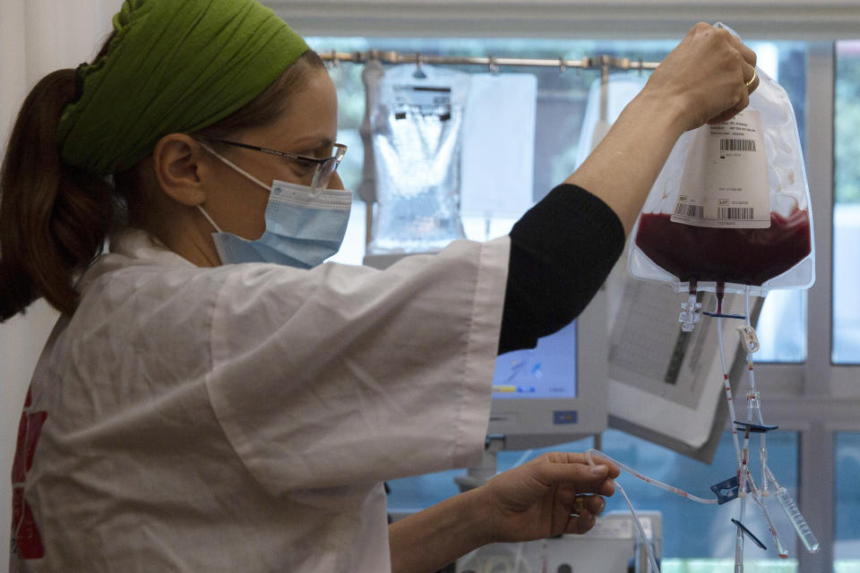 In this May 19, 2020 photo, a nurse holds bone marrow for transplant at the Israeli Ezer Mizion bone marrow registry, in the Israeli central city of Petah Tikvah. Over the past two months, as air travel has ground to a halt, Mishel Zrian has criss-crossed the Atlantic and the United States dozens of times, sleeping in empty airports and unable to return home to see his family in Israel, all in a race against time to deliver life-saving transplants. (AP Photo/Sebastian Scheiner)