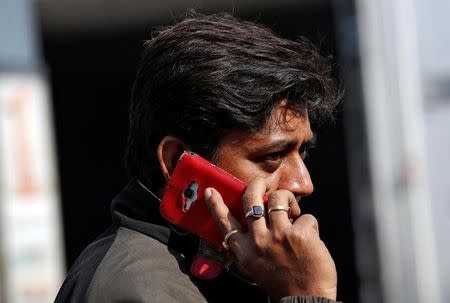 A man talks on his mobile phone while walking on a road in Kolkata, January 6, 2017. REUTERS/Rupak De Chowdhuri/Files