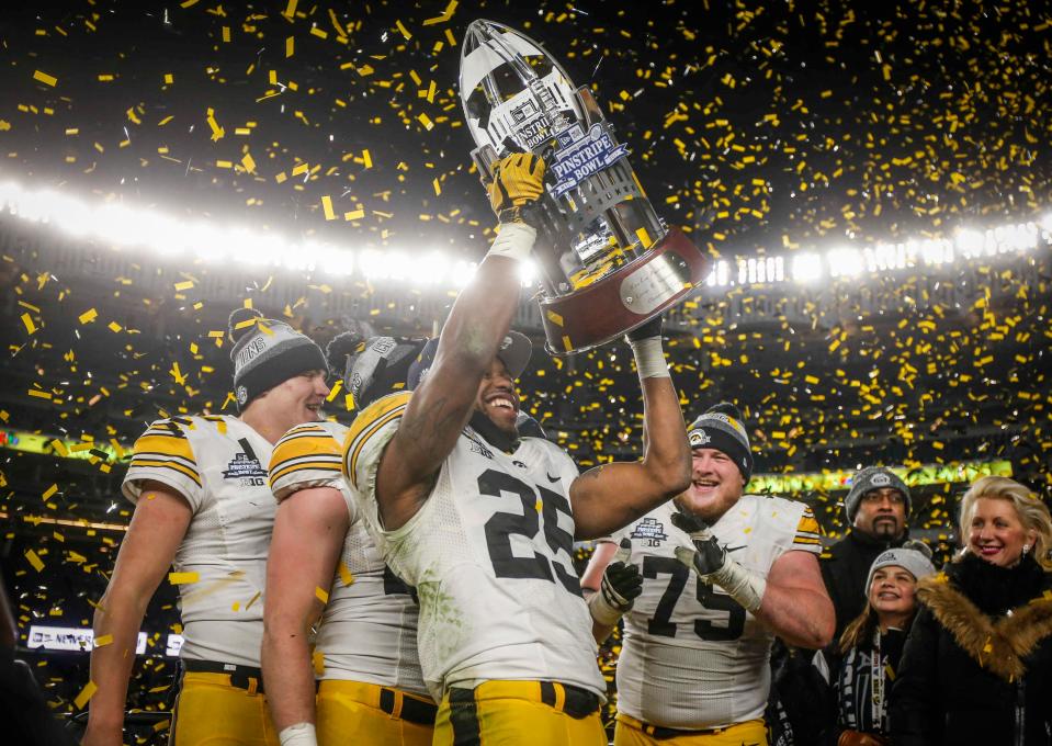 Iowa senior running back Akrum Wadley raises the 2017 Pinstripe Bowl trophy after the Hawkeyes beat Boston College, 27-20, during the 2017 Pinstripe Bowl at Yankee Stadium in Bronx, New York on Wednesday, Dec. 27, 2017.