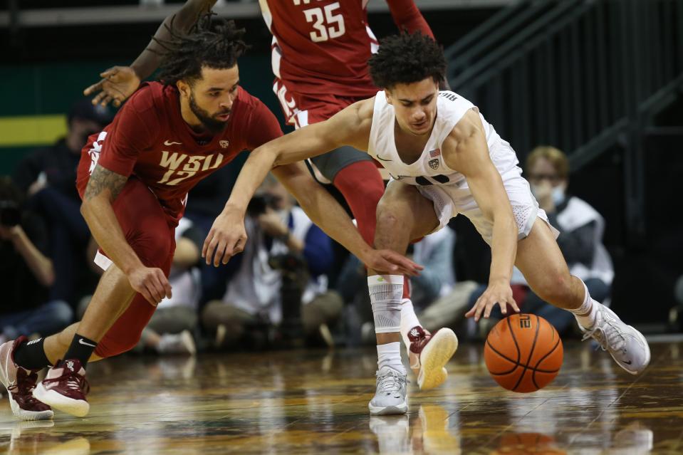 Washington State's Michael Flowers battles Oregon's Will Richardson for a loose ball during the first half against Washington State Feb. 14, 2022.