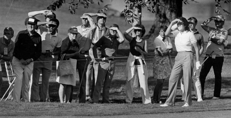 The outlook was bright for Nancy Lopez and her faithful gallery as she takes her second-round shot on the 18th hole at the 1982 (LPGA) Rochester International tournament.