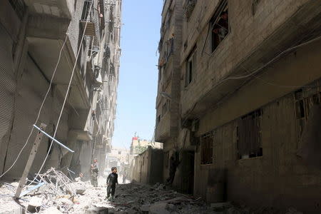 Residents inspect the rubble of collapsed buildings after what activists said was shelling by forces loyal to Syria's President Bashar al-Assad at Ain Tarma in eastern Ghouta, a suburb of Damascus, Syria April 26, 2015. REUTERS/Amer Almohibany