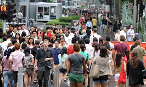 This file photo shows pedestrians crossing a street in Singapore's upmarket shopping area near Orchard Road, in 2011. 'Singaporeans are the least likely in the world to report experiencing emotions of any kind on a daily basis,' US-based pollster Gallup said in a report on a three-year study conducted in more than 150 countries